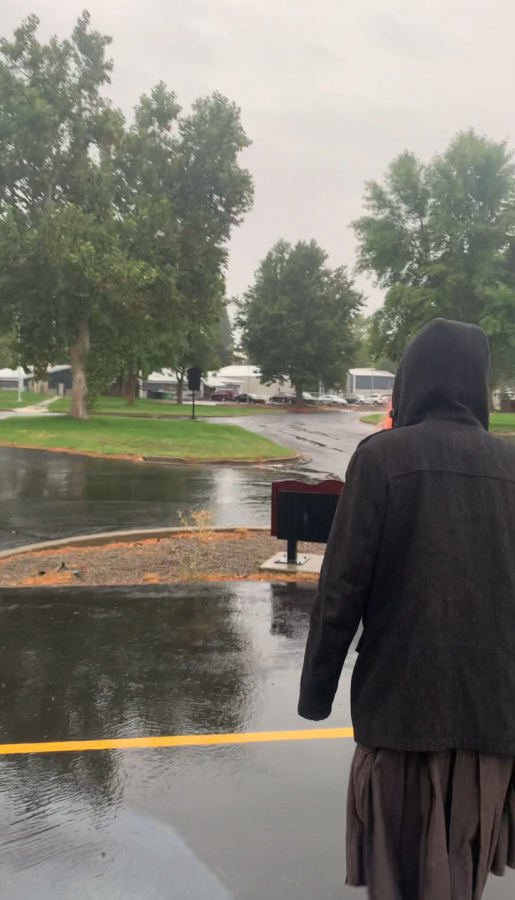 A student out enjoying the unexpected rainfall.
